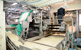コンベアで原料を搬送する製造ラインを監視する作業員の様子